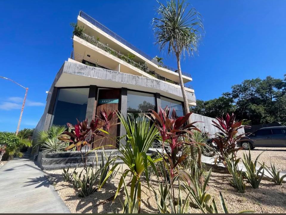 Seren building street-front entrance with tropical landscaping